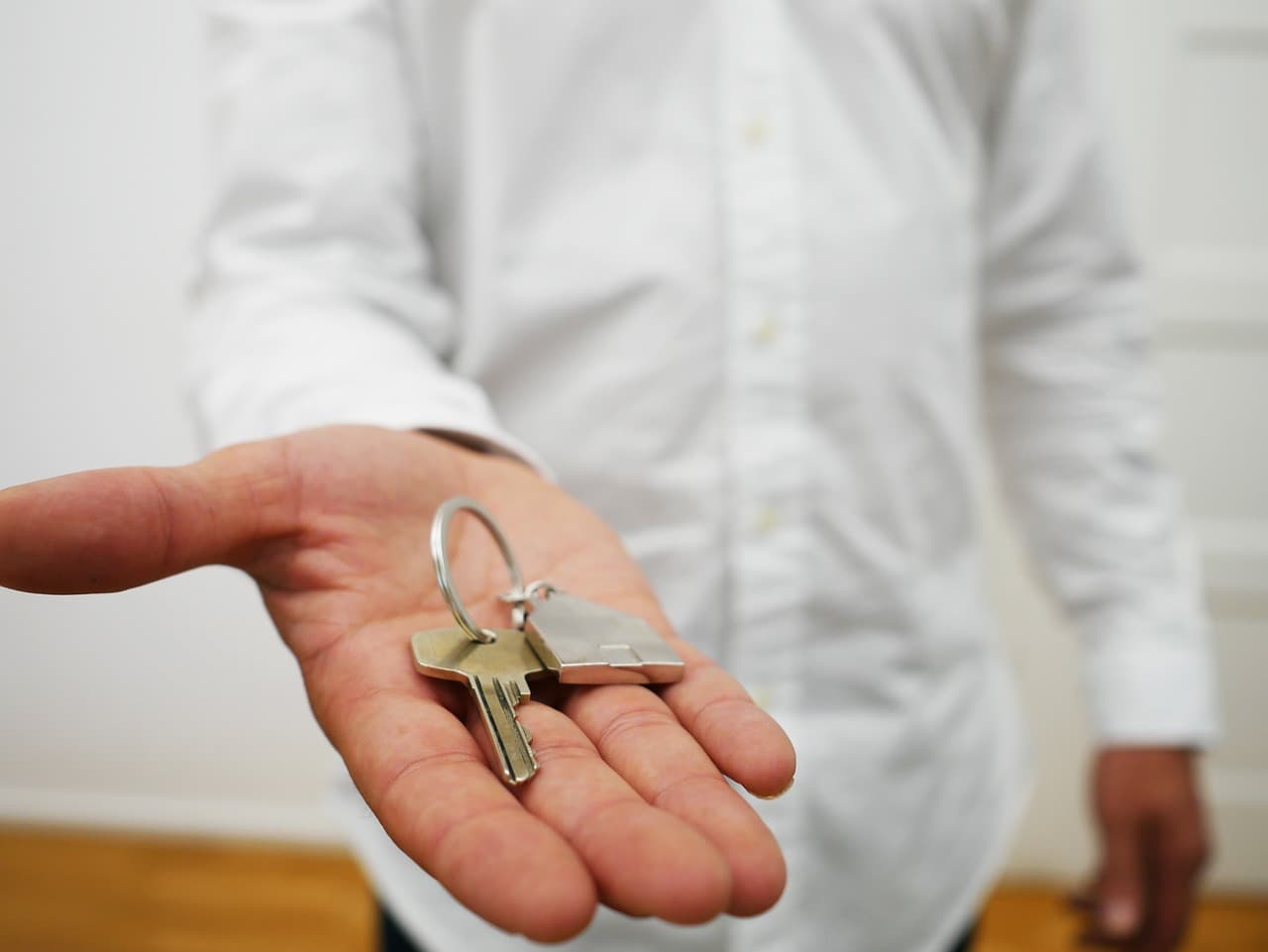 A hand holding out a set of newly cut keys